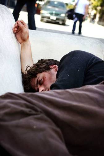 actor Francois Arnaud depicted sleeping rough, in 'What Makes Us Care?' at The Crypts gallery, St Martins-in-the-Fields, London. Photography by Kathryn Prescott.