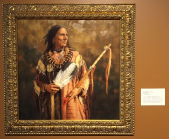Krystin Melaine, 'War and peace', 2008, oil on canvas, at Booth Western Art Museum, Cartersville, GA. Photo credit Kelise Franclemont. The card reads: 'A native of Australia, Melaine knew she wanted to be an artist. Her interest in Western American subjects emerged from her numerous trips to the United States. Although this Plains Indian subject wears the shirt of a warrior, he holds a peace pipe.'